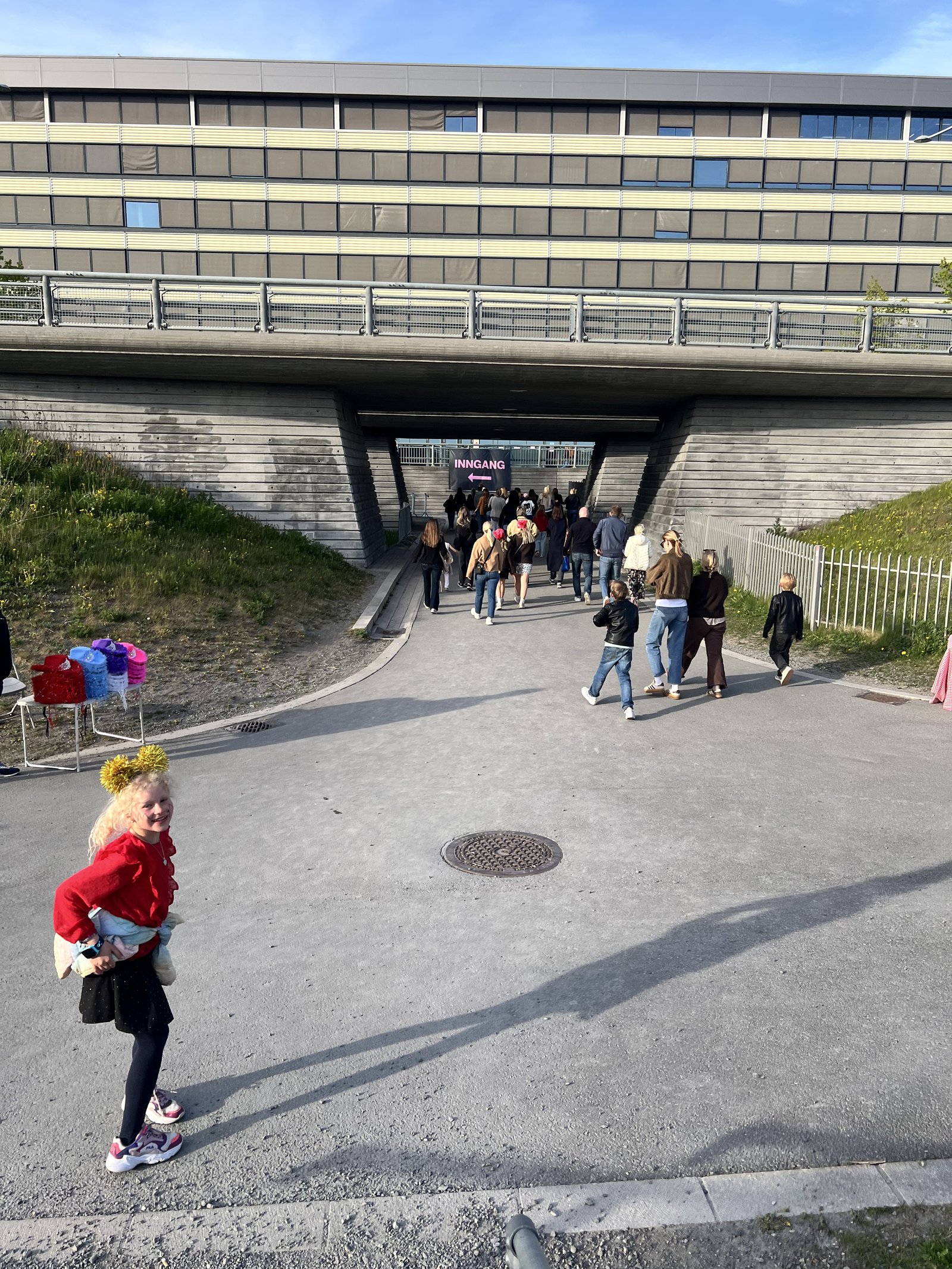 Gangveien under broen mot Unity Arena innganger, med cowboyhatt-selger til venstre
